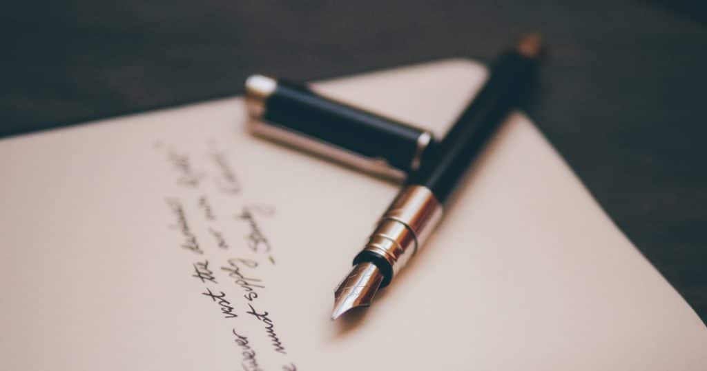 Close up of a fountain pen on a piece of paper with cursive writing