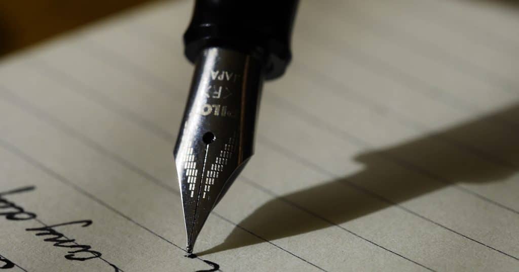 Quill pen writing in cursive on a will