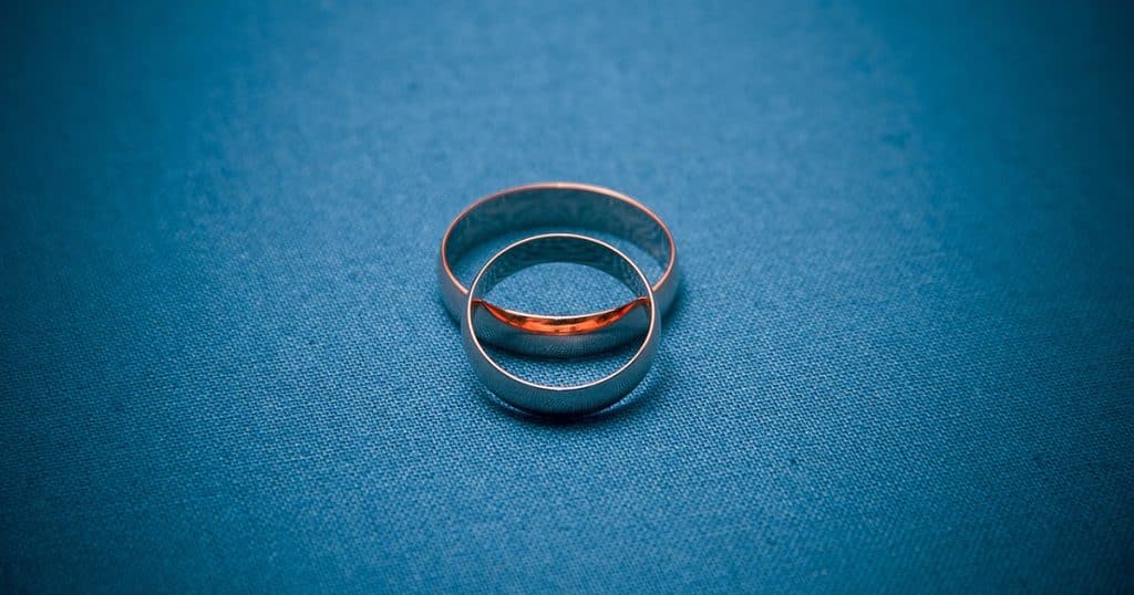Two wedding rings on a blue background