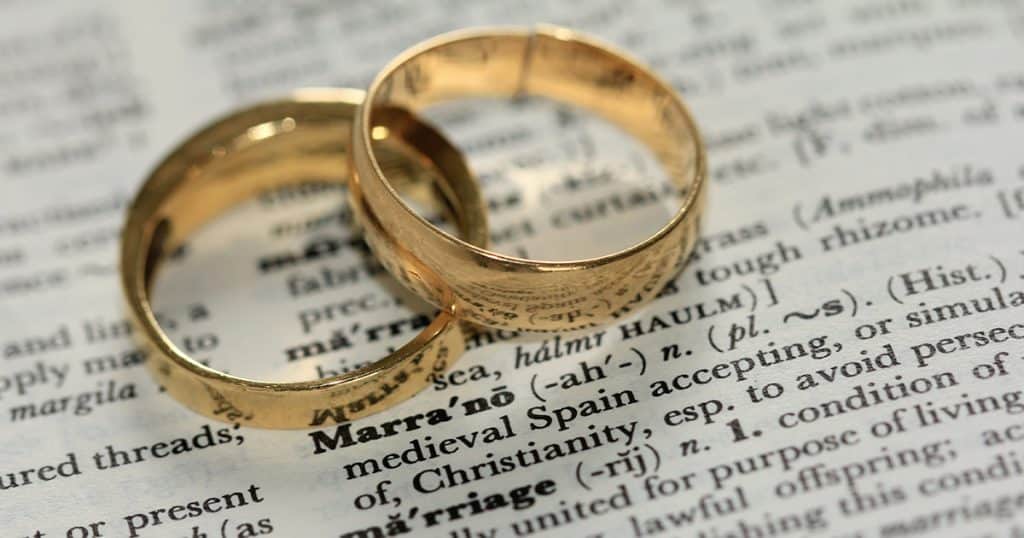 Two rings on a dictionary with the word marriage defined